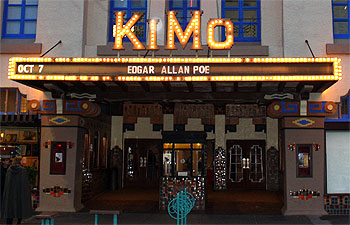 Exterior of a theater marquee at night, lit up wtih the words on the marquee reading: Oct 7 Edgar Allan Poe. The lit up name of the theater is KIMO.